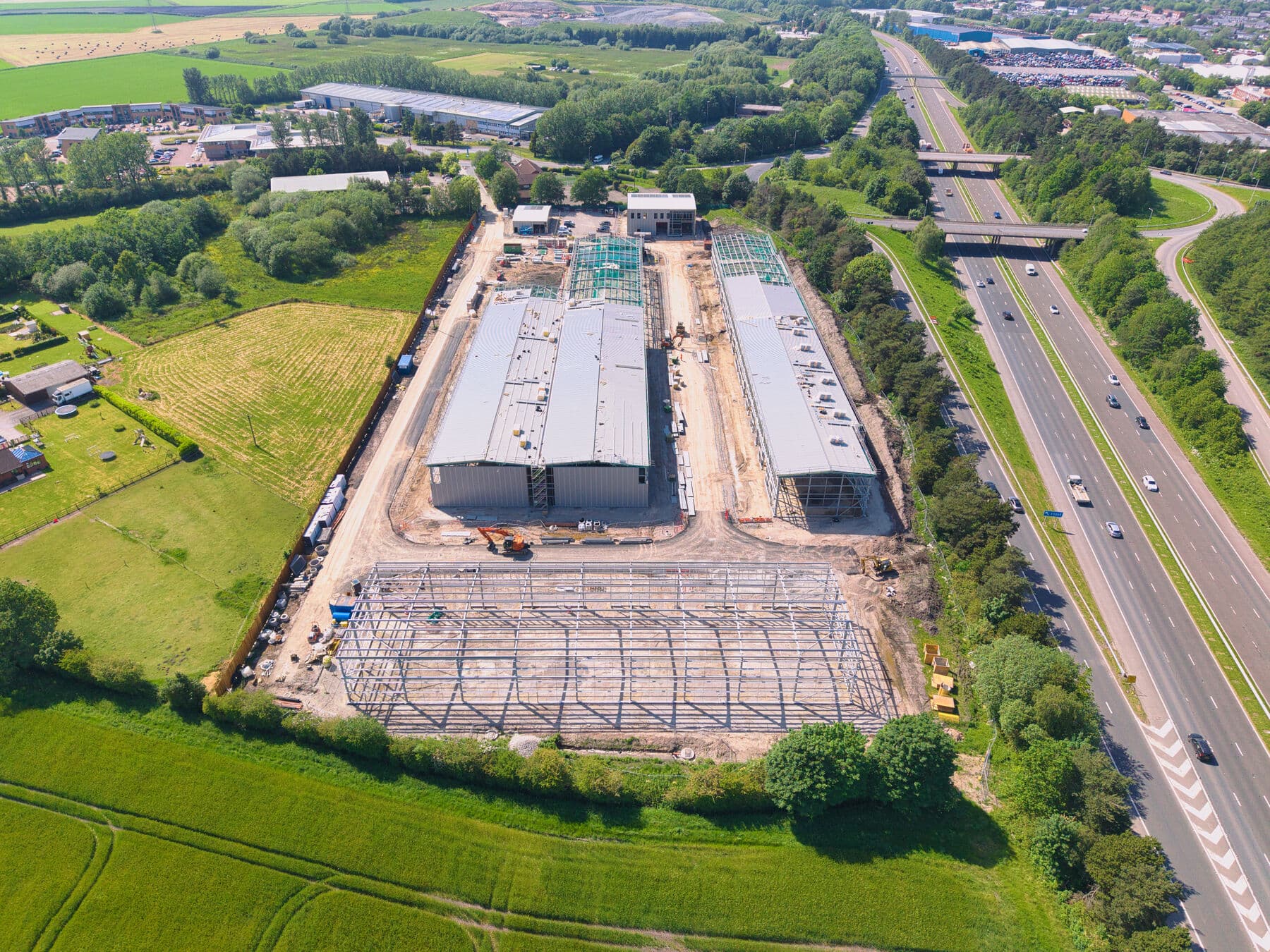 Aerial view of the Junction 4 development with the M58 motorway curving past the site